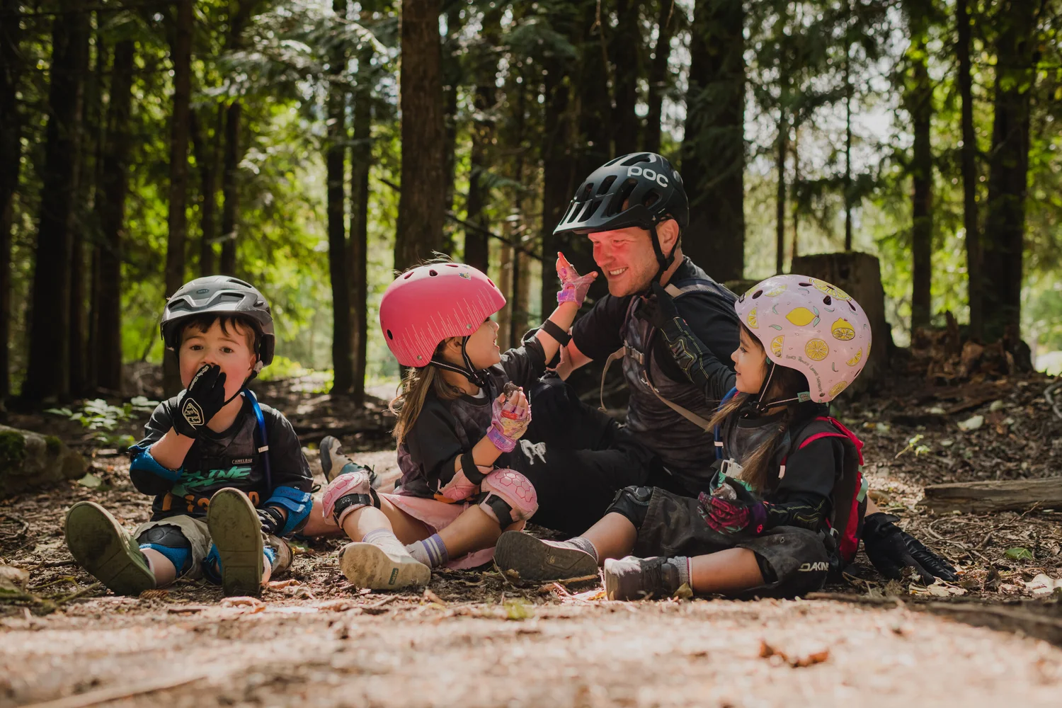 A coach high-fiving little campers on the trail